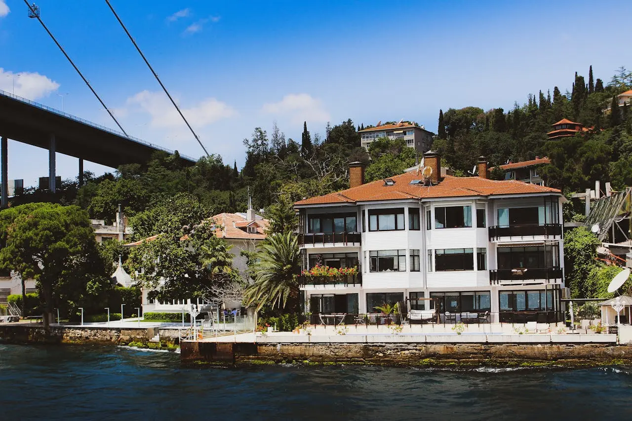 kelowna-condos-for-sale-downtown-highrise A modern glass high-rise condo building in downtown Kelowna with balconies overlooking the city and mountains.